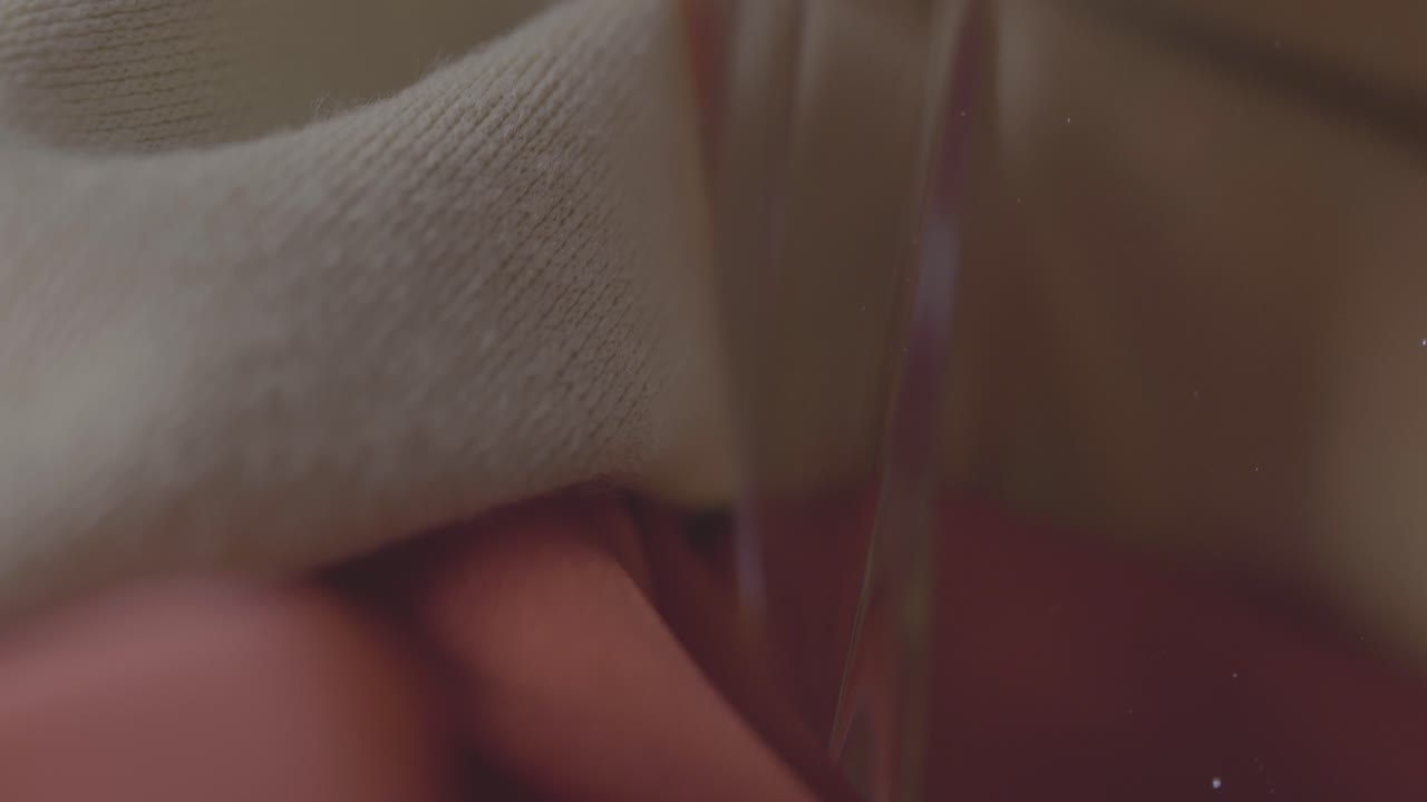 toma macro de una botella de perfume rodeada de textiles rosas y blancos