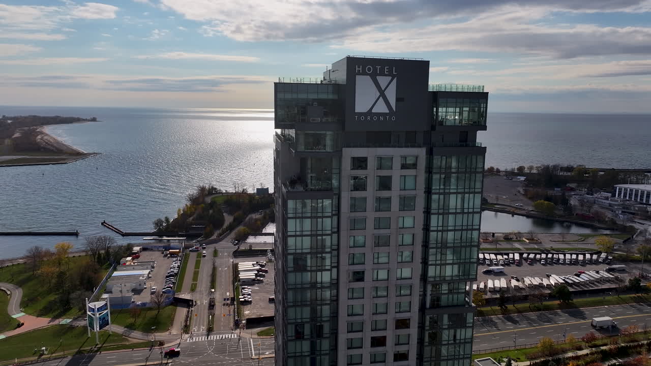 Drone orbiting around Hotel X by an urban city waterfront