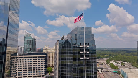 Waving-American-Flag-in-front-of-mirrored-Modern-Skyscraper-in-Atlanta-City