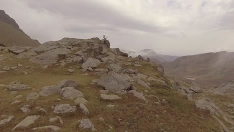 aerial shot of kosovo mountains with men standing still with arms open