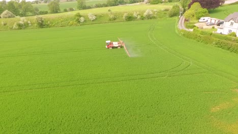 long side view of crop spraying by tractor in field