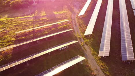 Aerial-drone-flying-above-Solar-Panel-photovoltaic-farm,-tilt-up-reveals-wind-turbines-at-sunset,-green-clean-energy-renewable-future,-ecology-concept