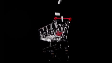 sugary chewing gum dropping in a miniature shopping trolley