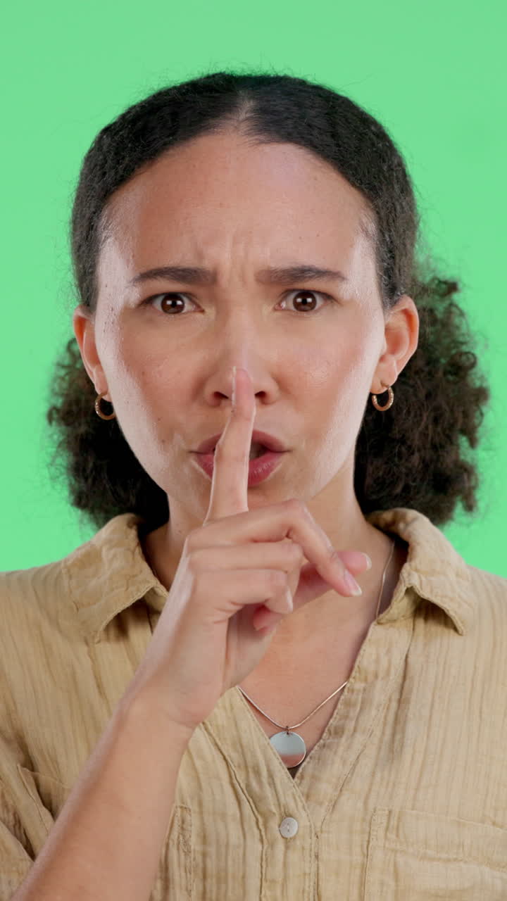 Donna seria che fa segno di silenzio con il dito sulle labbra