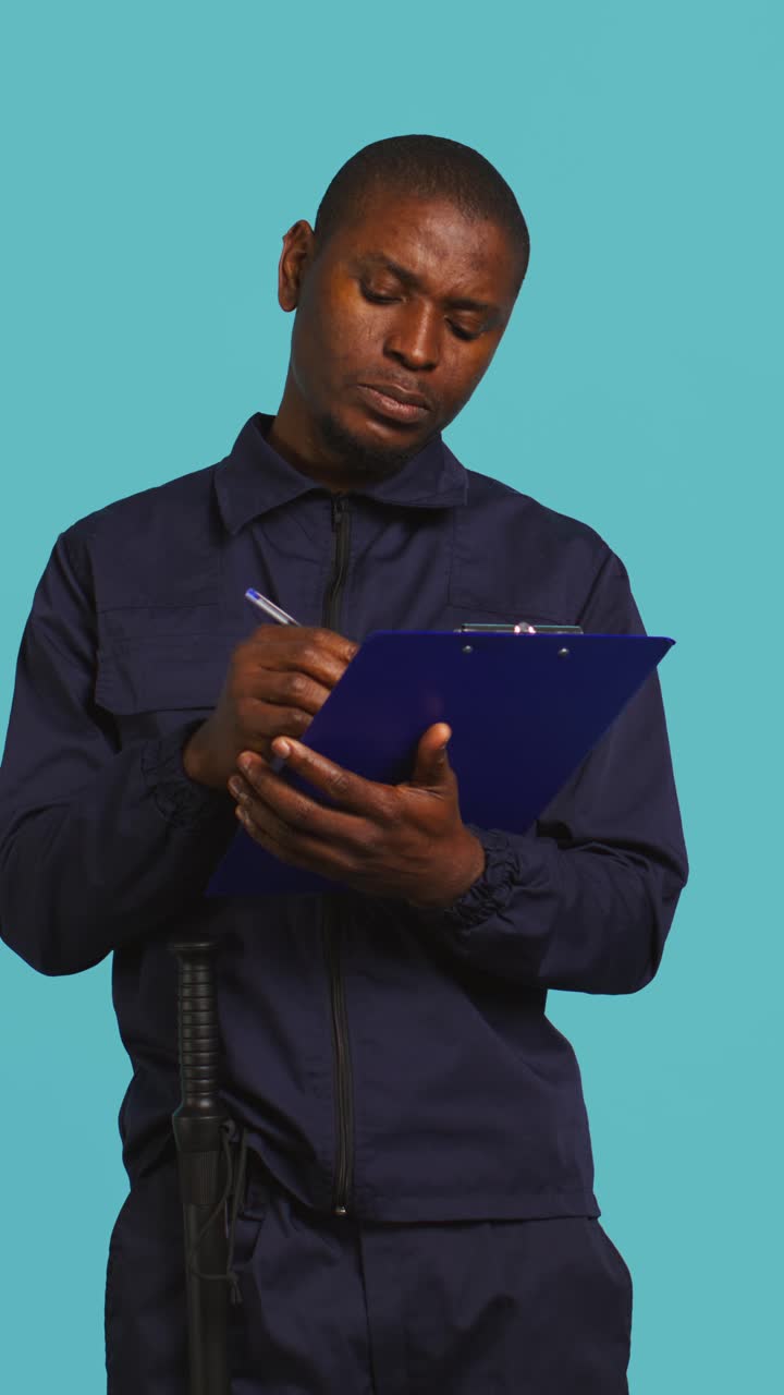 African American Man in Uniform Writing on Clipboard