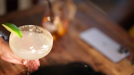 con un cóctel de margarita en la mano en un bar en phuket, tailandia