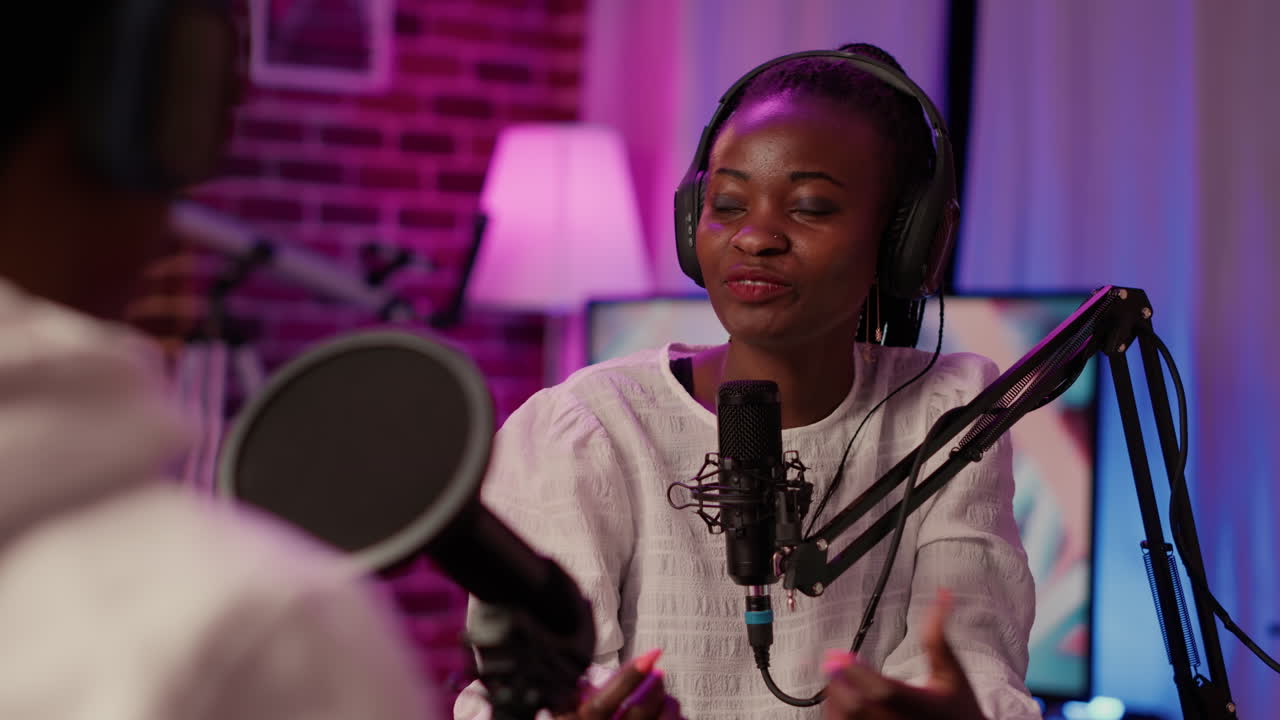 Closeup of african american podcaster in home recording studio in intervew with vlogger