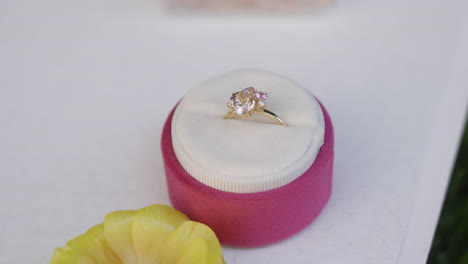 elegant gold ring with pink gemstones in a gift box