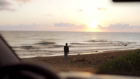a man came to see the ocean, happily walking to it. footage from the car
