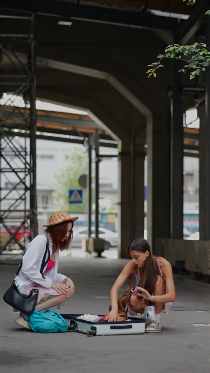 mujeres desempaquetando maletas en la estación de tren