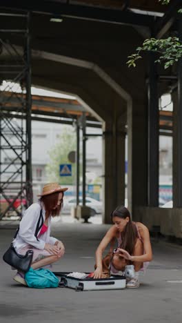 women unpacking suitcases at train station