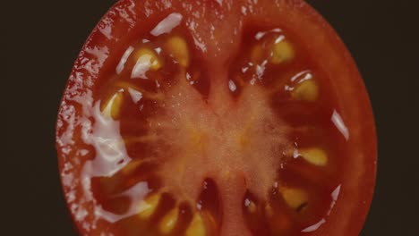 Rotate-of-the-halves-of-fresh-ripe-cut-tomato-on-a-dark-background