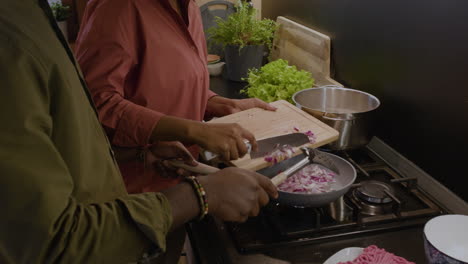 una pareja cocinando en la cocina.