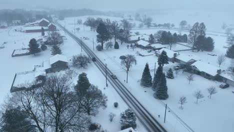 driving car on snowy dangerous road in rural village of usa