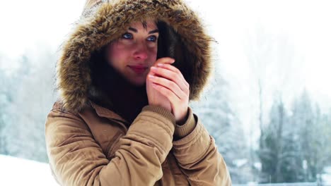 woman in fur jacket warming her hands