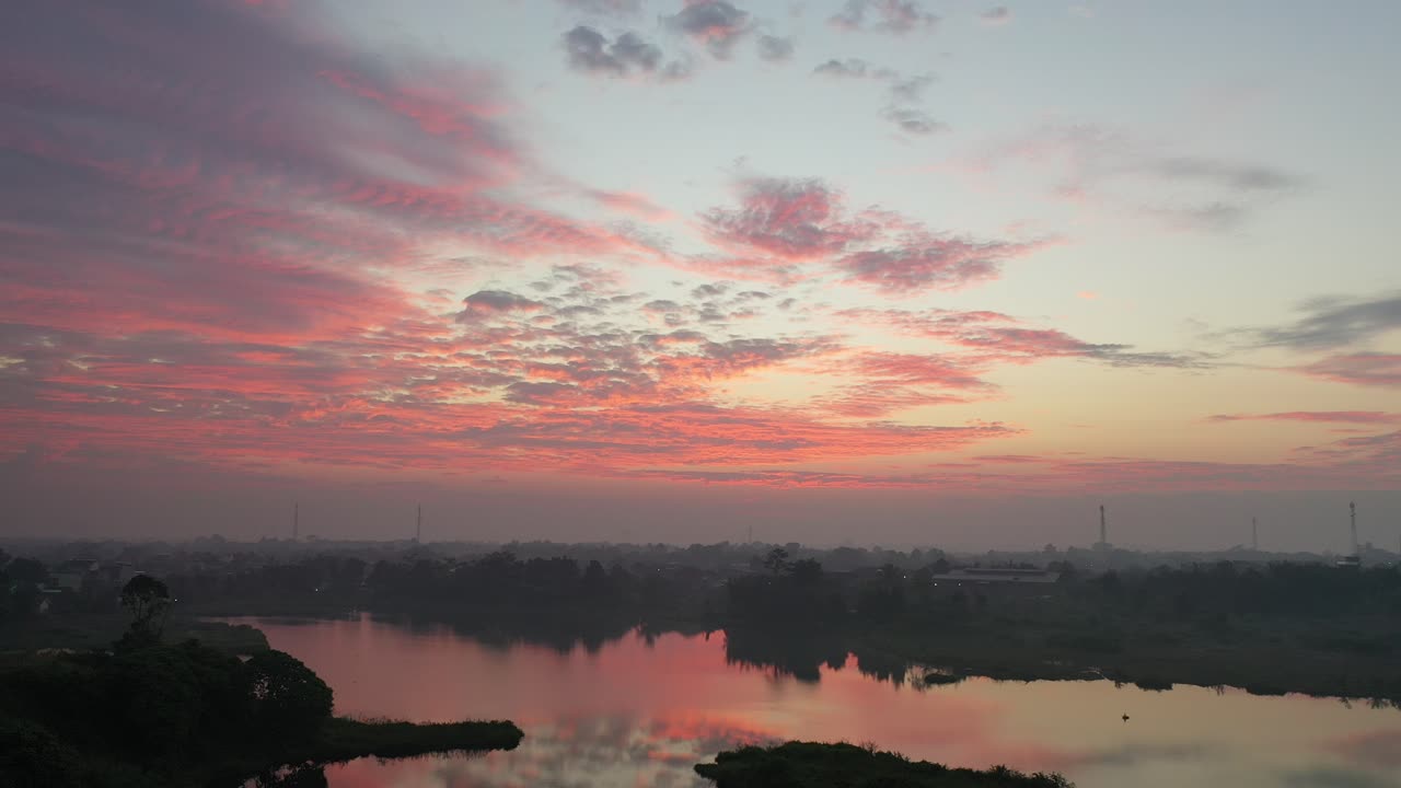 amanecer rosado sobre un lago y paisaje urbano