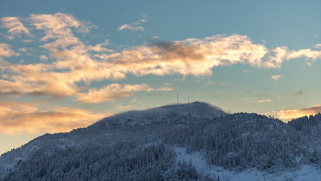 nubes doradas y chubascos de nieve sobre la cumbre de una montaña nevada en noruega