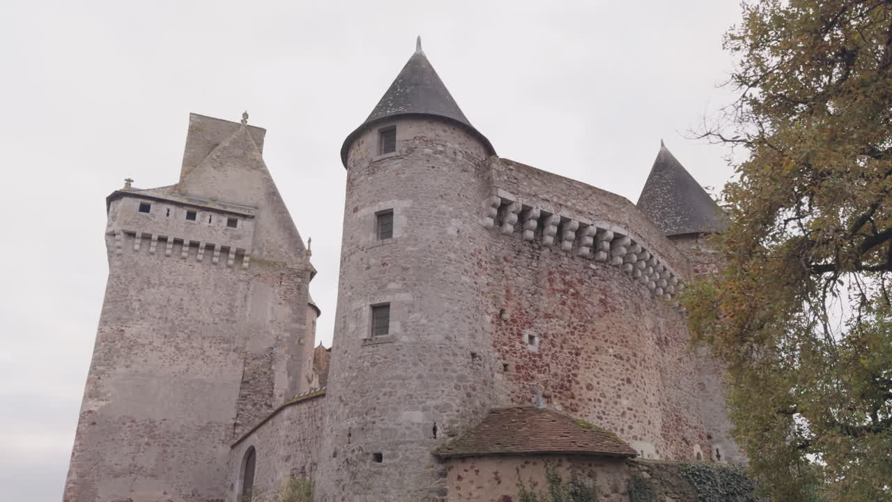 Ancient Château du Bouchet in Rosnay, France, with stone towers under a cloudy sky