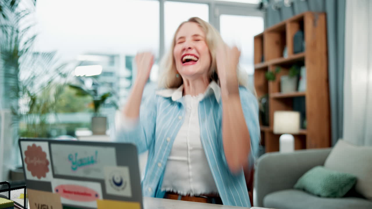 Excited woman celebrating success at her desk