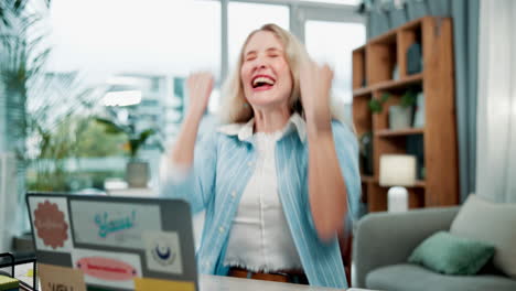 excited woman celebrating success at her desk