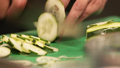 chef experto cortando rápidamente pepino con un cuchillo afilado en la cocina de un restaurante