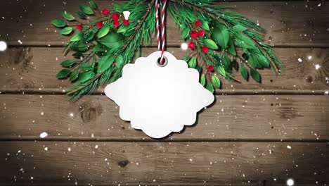 Animation-of-christmas-tag-with-copy-space,-decorations-and-snow-falling-on-wooden-background