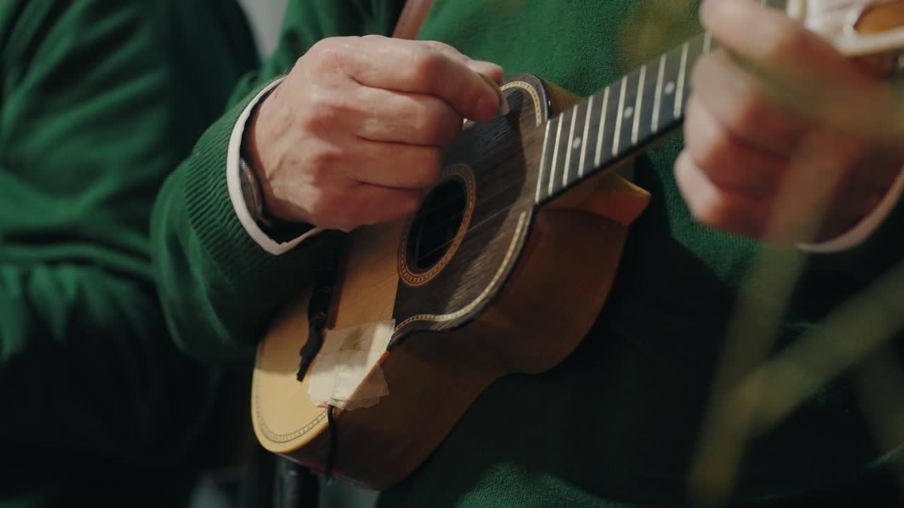 Close up of a musician playing a cavaquinho during a traditional event in Minho Portugal