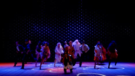 artistas en trajes escénicos y con pintura de grasa están bailando en el escenario en el teatro