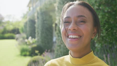 portrait of happy biracial woman looking at camera and smiling with copy space, in slow motion