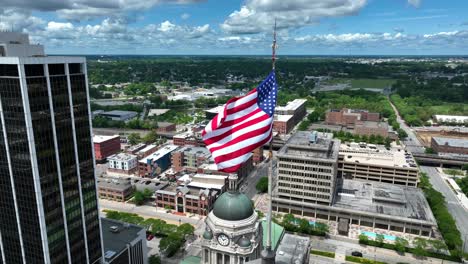 Bandera-Americana-Ondeando-Sobre-El-Centro-De-Fort-Wayne,-Indiana