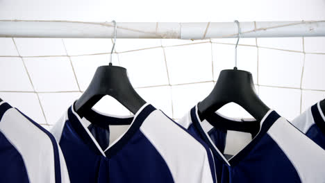 camiseta azul colgada en el poste de la portería contra un fondo blanco 4k