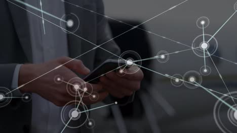 animación de la red de conexiones sobre las manos de un empresario caucásico usando un teléfono inteligente