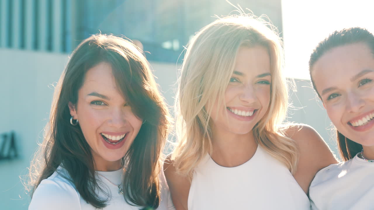 세 명의 행복한 여자 친구들이 도시를 즐기고 있습니다.