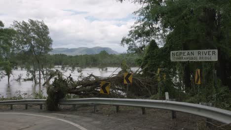 nepean river sign surrounded by devastation caused by heavy flooding