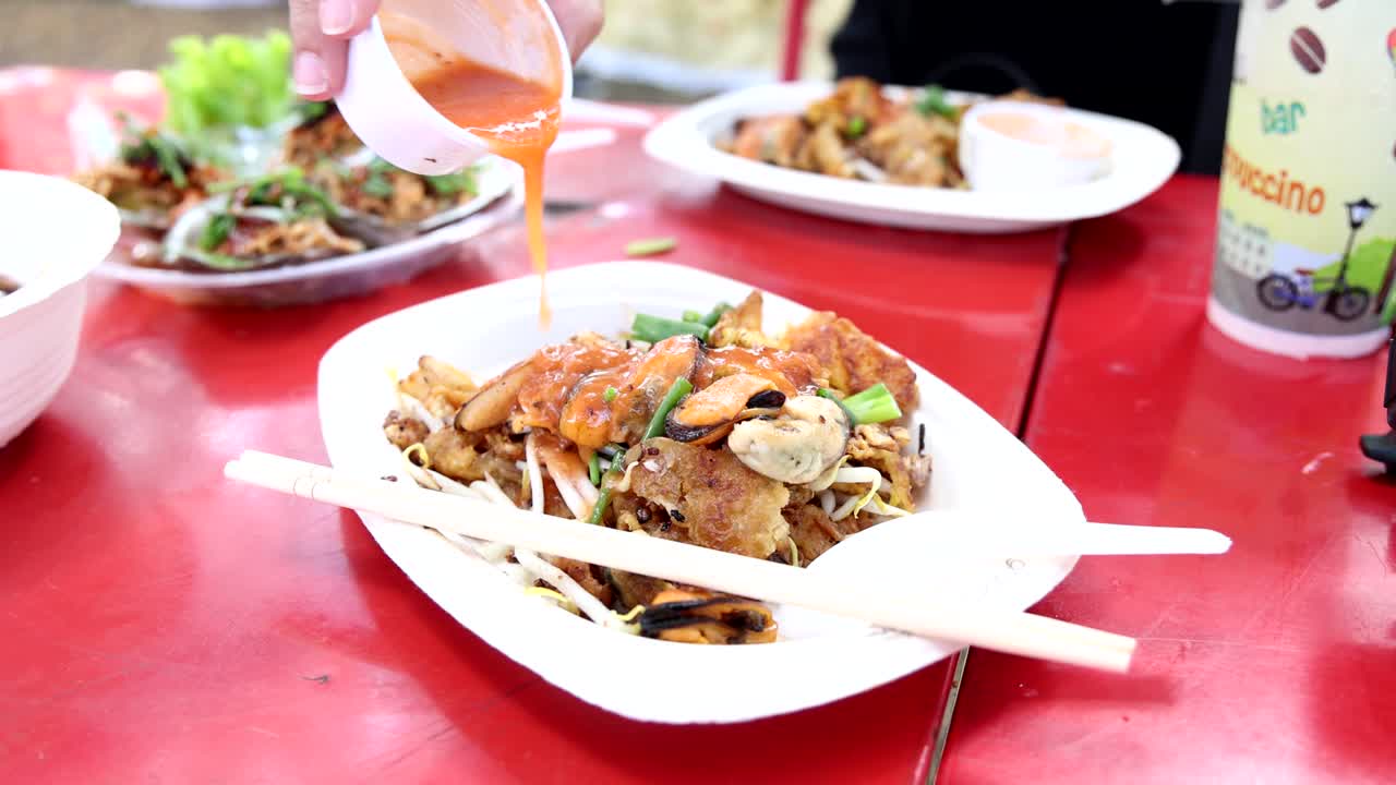 매운 누들 요리 위에 소스를 부어 넣는 것