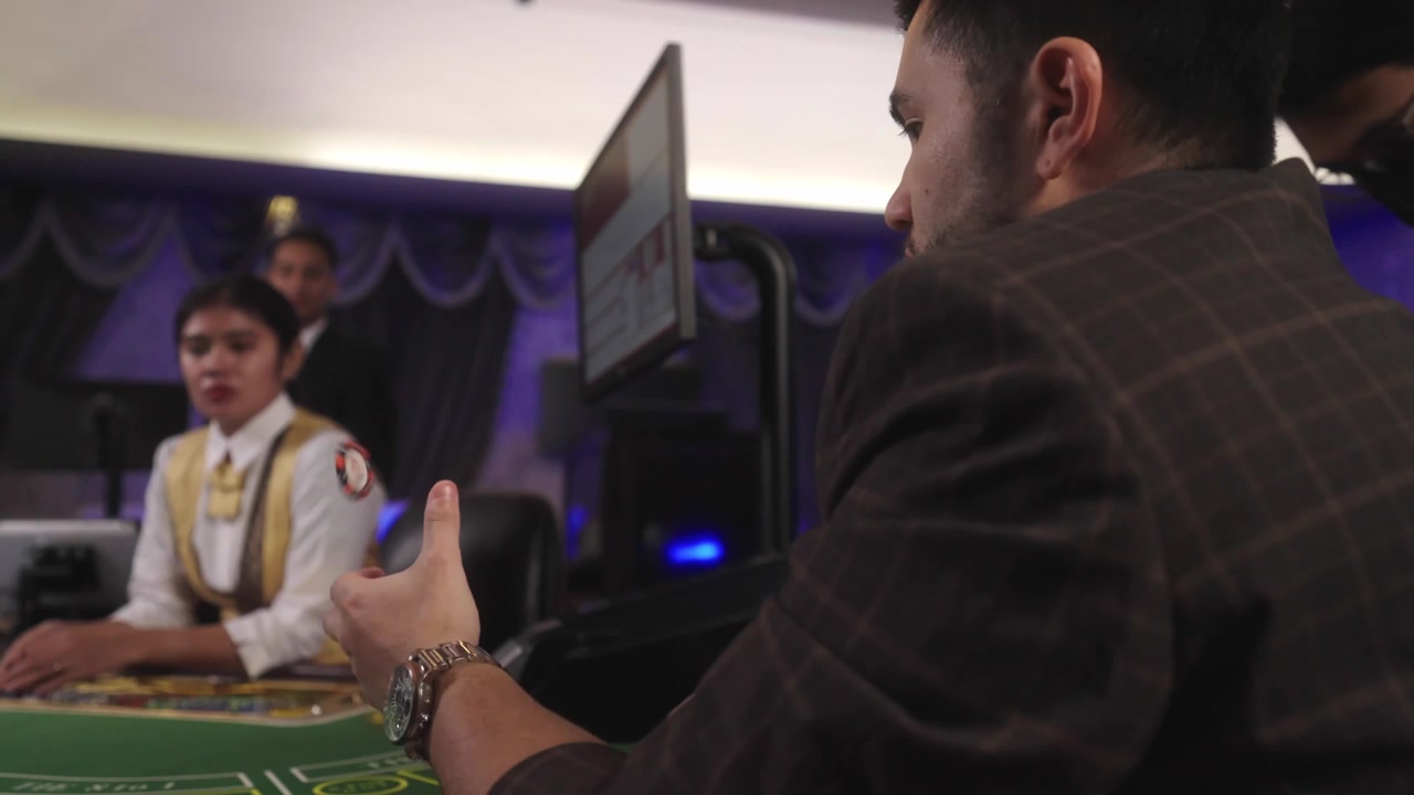 Gioco da tavolo da casinò commerciale con la scena di un giocatore maschio che fa girare e lancia fiches da casinò mentre aspetta il suo turno di gioco