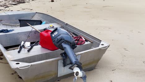 aerial view of a small, empty boat on a sandy beach, captured by a drone in natural lighting