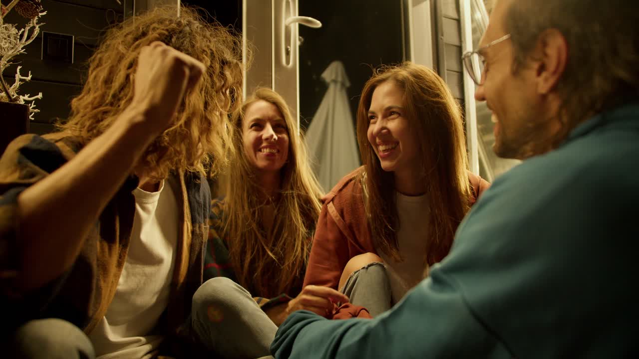 두 소녀와 두 소년의 회사가 재미있게 대화하고 있습니다. 소년들은 소녀의 머리카락을 고치고 시골 집에서 휴식을 취합니다.