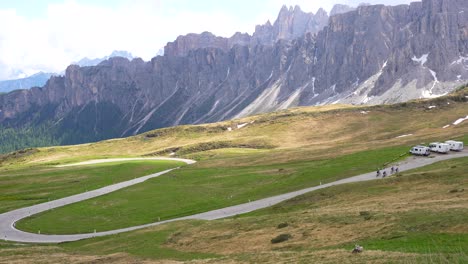 Ciclistas-Subiendo-Cuesta-Arriba-En-El-Paso-De-Giau,-Fondo-De-La-Cordillera-Rocosa,-Italia