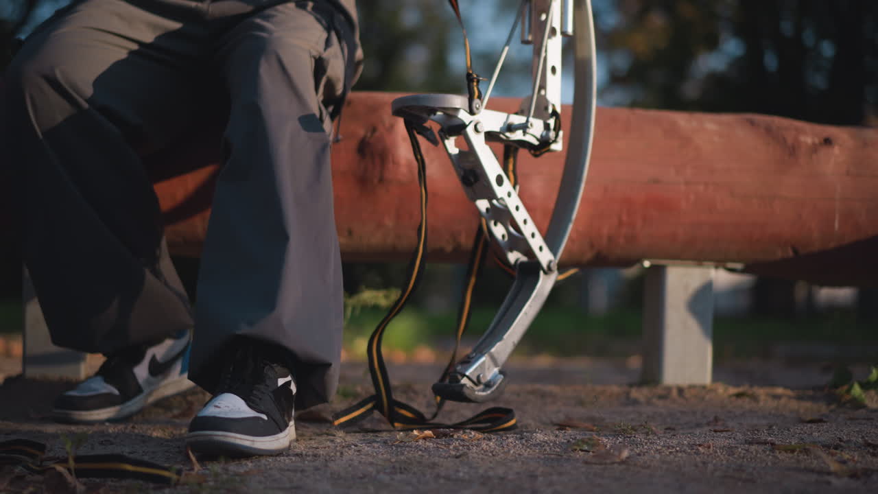 atleta enfocado ajusta el equipo de tiro con arco en un entorno al aire libre soleado, mostrando precisión y habilidad mientras se prepara para la práctica o la competencia