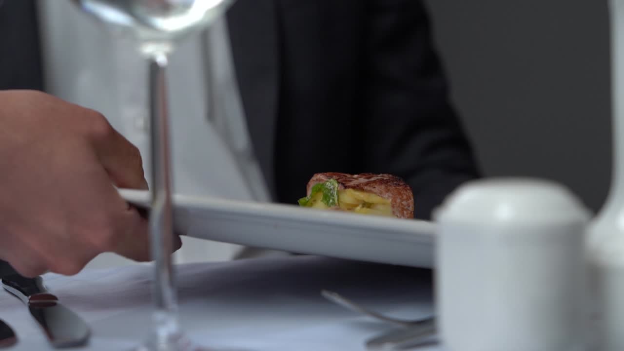 A gourmet dish being served to a guest at a fancy, upscale restaurant.