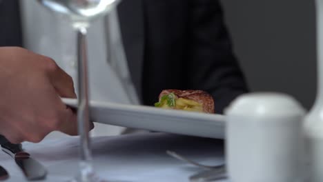 a gourmet dish being served to a guest at a fancy, upscale restaurant.
