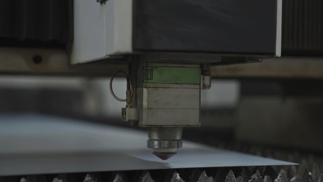 Industrial CNC machine laser moving down on metal sheet, precision cutter