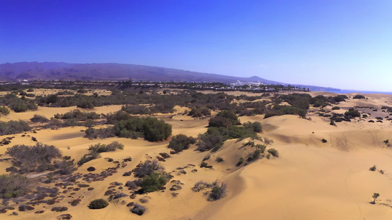 vuelo aéreo de drones de las dunas sobre dunas en la playa de las palmas en gran canaria con barcos en agua de mar en el océano atlántico