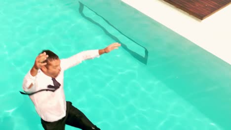 businessman with briefcase jumping in the swimming pool