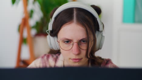 estudiante concentrado usando una computadora portátil con auriculares