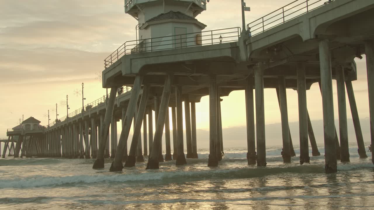 huntington beach pier with waves at sunset