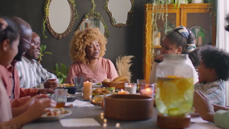 african american woman chatting with family at holiday dinner
