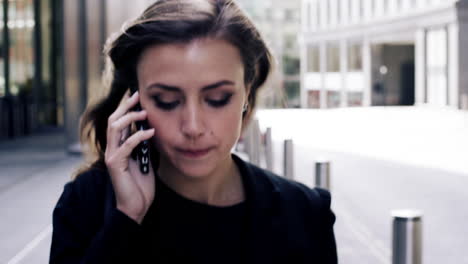 atractiva mujer de negocios viajera que usa un teléfono inteligente caminando en la ciudad de londres