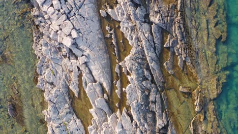 Beautiful-hard-rock-coastal-formation-on-tropical-Croatian-coastline,-aerial